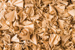 © KPixMining - Beautiful spiral curled wooden sawdust in texture detail. Abstract close-up of wood shavings scattered on pile as decorative background. By-product of milling, routing or drilling. Woodworking waste.