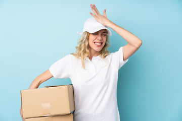 Young delivery woman isolated on blue background having doubts with confuse face expression