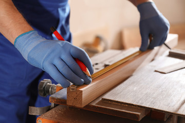 Sticker - Professional carpenter measuring wooden bar in workshop, closeup