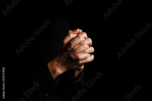 Fotomural Image of praying hands on a black background