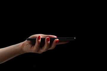 woman hands using modern mobile phone on black background