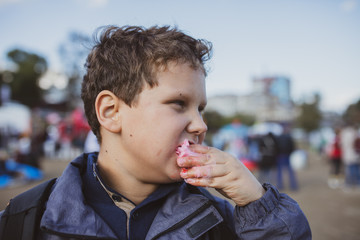 Wall Mural - The boy eats red cotton candy