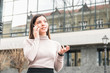young attractive and confident businesswoman speaking on the phone in front of business centre