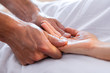 Close-up view of masseur giving relaxing hand massage to a client. Hand massage to a woman in a cosy home environment. Massage and body care
