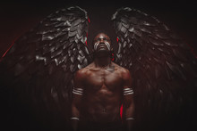 Young Strong Black Angel With Cool Wings, Stand Posing At Camera. Man Fall From Heaven, Angel With Muscular Body Gained Freedom. Fantasy Concept, Unusual Creative Photoshot