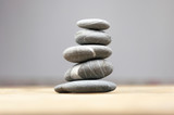 Fototapeta Desenie - Stack of stones on wooden table, space for text. Zen concept