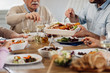 © Drazen - Close-up of multi-generation family eating lunch at dining table.