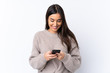 © luismolinero - Young brunette woman over isolated white background sending a message with the mobile