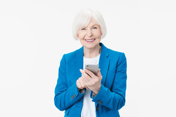 Smiling senior woman holding smartphone using mobile online apps over white background