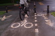 © cineos - Restrictive posts between the pedestrian sidewalk and the road. poles of yellow-black color, striped with bicycle icon on the road