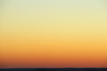 Wall Mural - flaming sky over the horizon during sunset or sunrise. bright iridescent colors of yellow, orange an
