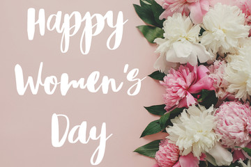  Happy Women's day text. Happy Women's day lettering on  stylish pink peonies flat lay. Floral greeting card.  Beautiful peony flowers, tender image. 8 march. International womens day