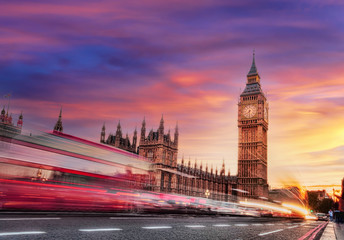 Big Ben with red bus against colorful sunset in London, England, UK