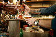 © chika_milan - Tattooed caucasian barman pouring beer while standing in pub. Selective focus on hand.