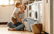happy family mother housewife and child   in laundry with washing machine .