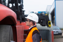 worker with helmet near a crane