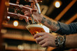 © chika_milan - Tattooed caucasian barman pouring beer while standing in pub. Selective focus on hand.