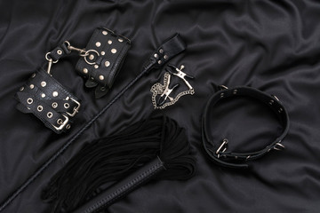 Wall Mural - Leather handcuffs, black whip, chain collar, nipple clamps and stack on black