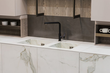 Modern kitchen white marble texture, black faucet and marble sink, hanging wooden sideboard shelves