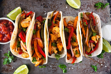 Canvas Print - Grilled spicy cauliflower fajitas. Top view scene over a dark background. Healthy eating, plant-based meat substitute concept.