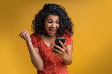 Wall Mural - Portrait of attractive young african american girl using mobile phone