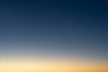 Heaven at early morning with copy space. Sunset, sunrise backdrop.Predawn clear sky with orange horizon and blue atmosphere. Smooth orange blue gradient of dawn sky.