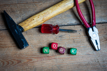 Different tools and the letters work on a wooden surface