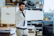 © Dusan Petkovic - Focused serious caucasian bearded supervisor in suit and tie looking at proof while standing in printing shop.