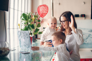 mother with two children talking video laptop