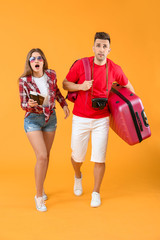 Sticker - Worried couple of tourists with luggage on color background