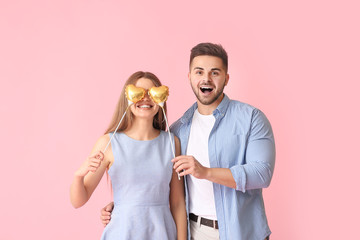 Canvas Print - Happy young couple with hearts on color background