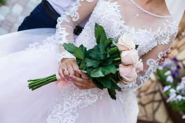 Bride in white dress holds a bouquet of flowers