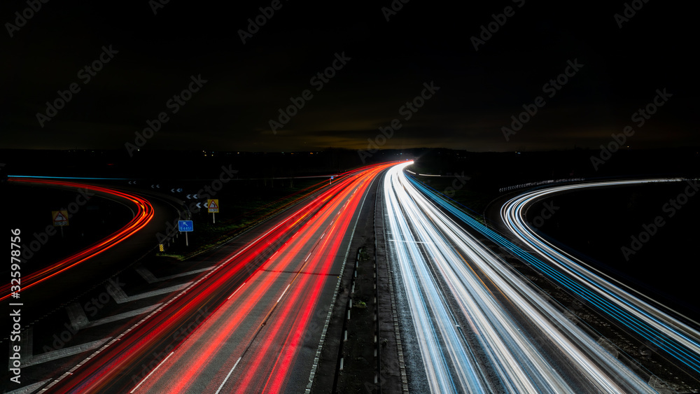 Motorway traffic light streaks with curved off ramps	 - obrazy, fototapety, plakaty 