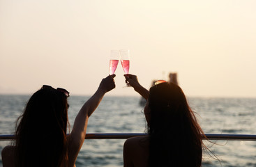 Beautiful Asia two young woman smile portrait traveling and drinking wine on speed boat in summer for relaxation at Thailand.