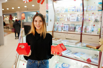 Wall Mural - Portrait of young caucasian female woman seller hold red gift boxes. Small business of candy souvenirs shop.