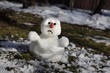 Snowman is melting in the sun. Thaw, warm winter, early spring, global warming, climate change background.