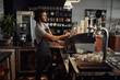 © StratfordProductions - Cheerful caucasian coffee shop owner wearing apron preparing coffee using machine
