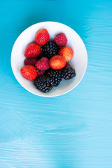 Wall Mural - Berry fruit on blue background.