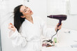 © Drobot Dean - Optimistic young woman dry hair with hair dryer.