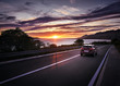 Wunderschöner Blick aufs Meer beim Sonnenuntergang und ein Auto fährt am Betrachter vorbei.