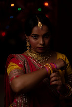 Portrait Of An Indian Bengali Beautiful Brunette Woman In Front Of The Colorful Light Bokeh Background Created By Tiny Chain Lights  In The Evening Of Diwali. Indian Lifestyle And Religion.