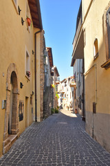 A narrow street between the old stone houses of a medieval village.