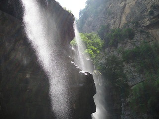 Mystical view to waterfall cascades with a wall of spray and sunlight