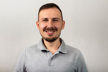 Portrait of a handsome smiling man in an gray shirt