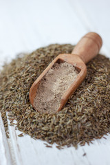 Canvas Print - Grounded cumin seeds in a wooden spoon over the seeds