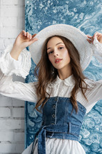 Fashionable Woman Wearing Wicker Hat, Trendy Blue Denim Corset, Vintage Style White Blouse. Spring, Summer Fashion Concept