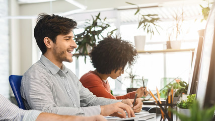 Aufkleber - Young guy enjoying his job, working with colleagues in office