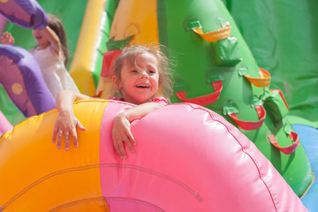 Wall Mural - A cheerful child plays in an inflatable castle