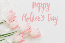 Happy Mother's Day.  Happy Mothers Day Text And Pink Tulips Floral Border On White Background. Stylish Soft Image. Floral Greeting Card. Happy Mothers Day. Handwritten Lettering