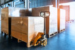 Packaging Boxes on Pallets Racks with Hand Pallet Truck in Storage Warehouse. Supply Chain. Storehouse Shipment Goods. Distribution Warehouse Shipping Logistics.	